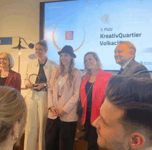 Moment der Preisverleihung - Christa, Ellen und Steffi stehen zwischen der Jury und posieren für ein Foto